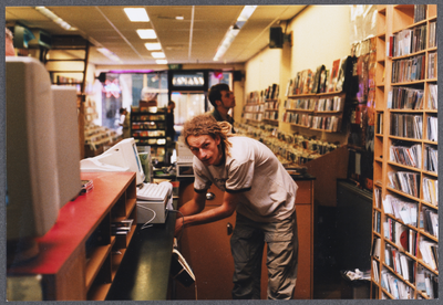 606441 Interieur van muziekwinkel Plato (Steenweg 13) te Utrecht: de verkoop- en luisterbalie, met enkele medewerkers.